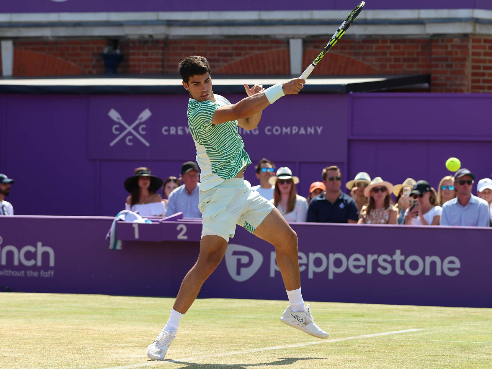 Carlos Alcaraz hitting the tennis ball during a match on Centre Court at the Queen's Club for the 2023 cinch Championships