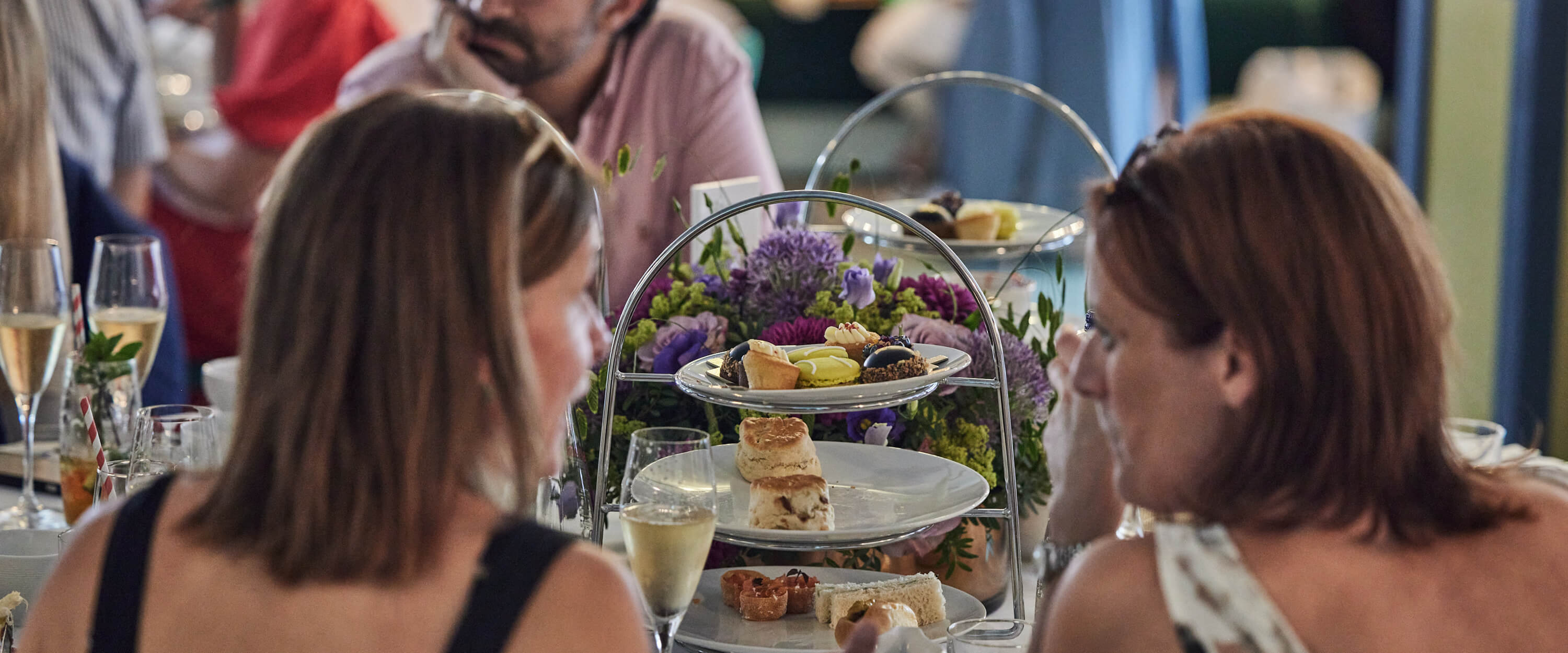 Guests chatting and enjoying hospitality over afternoon tea at The Championships Wimbledon in Rosewater Pavilion