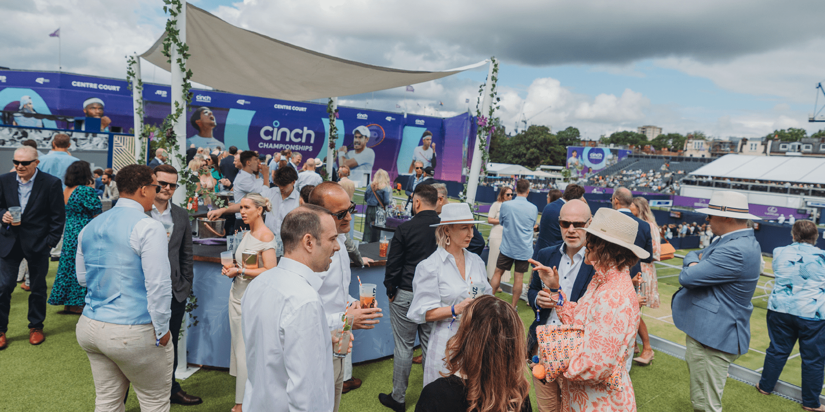 Guests enjoying drinks on the Roof Garden private balcony overlooking the practice courts at The Queen's Club for the championships