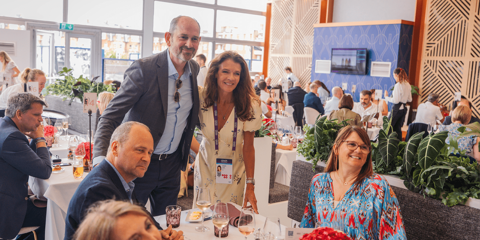 Guests in hospitality facility Club Lounge smiling for a photo with former British tennis player and commentator Annabel Croft