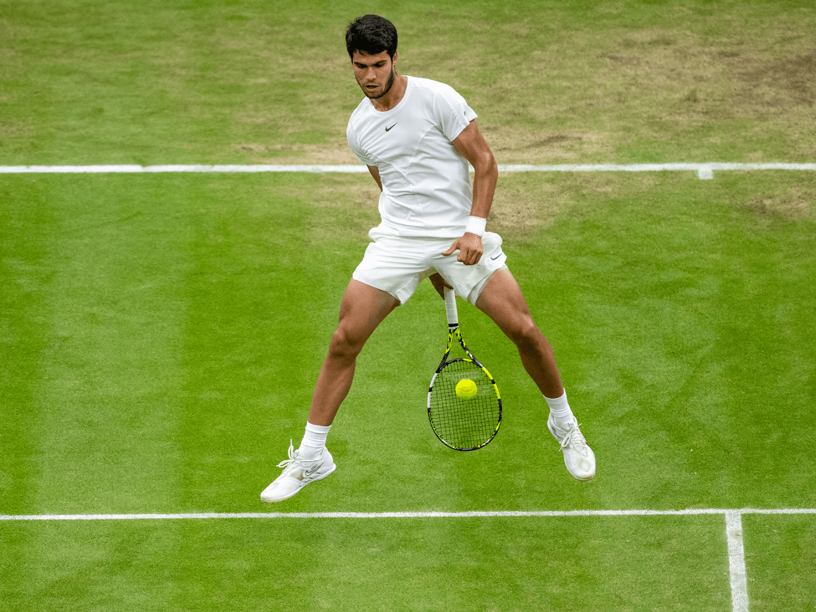 Men's tennis player and Wimbledon 2023 champion Carlos Alcaraz hitting a tweener shot on Centre Court at Wimbledon in a match