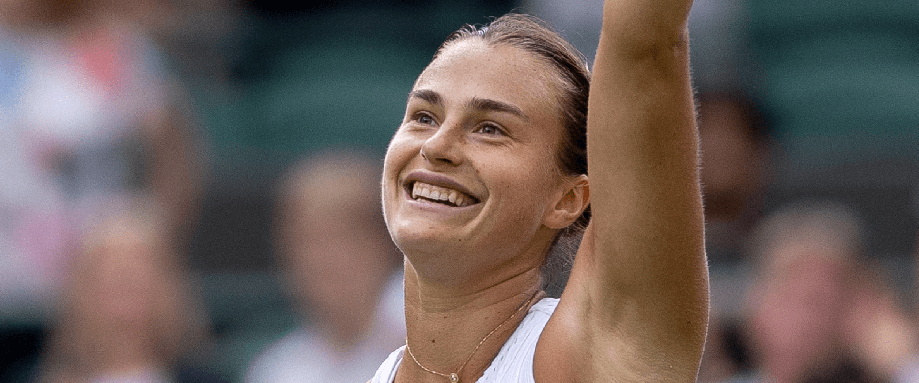 Women's tennis player Aryna Sabalenka smiling and putting her hand up during The Championships Wimbledon 