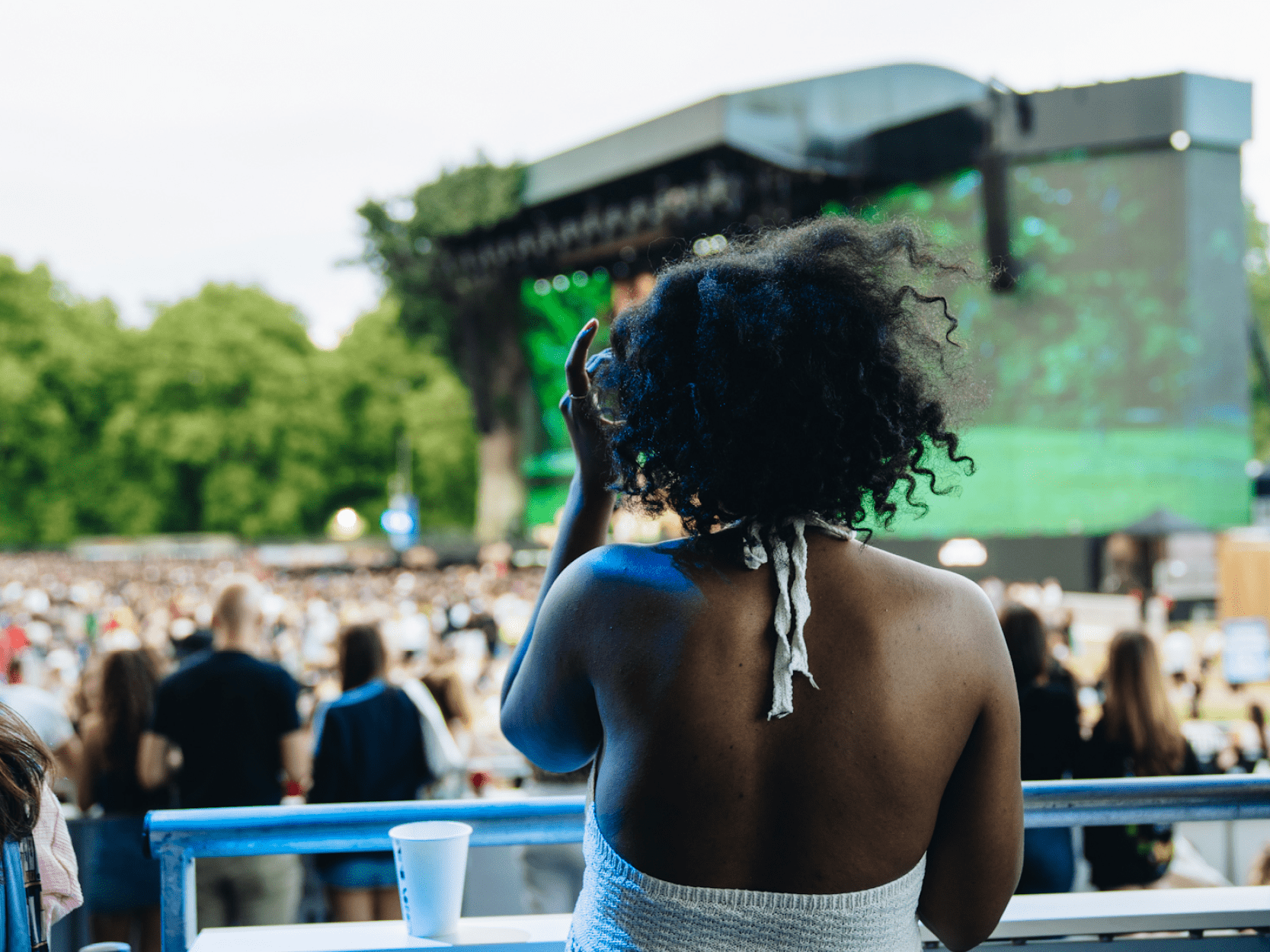 A lady looking out at the stage and crowd from the Great Oak Roof Garden Terrace at BST Hyde Park