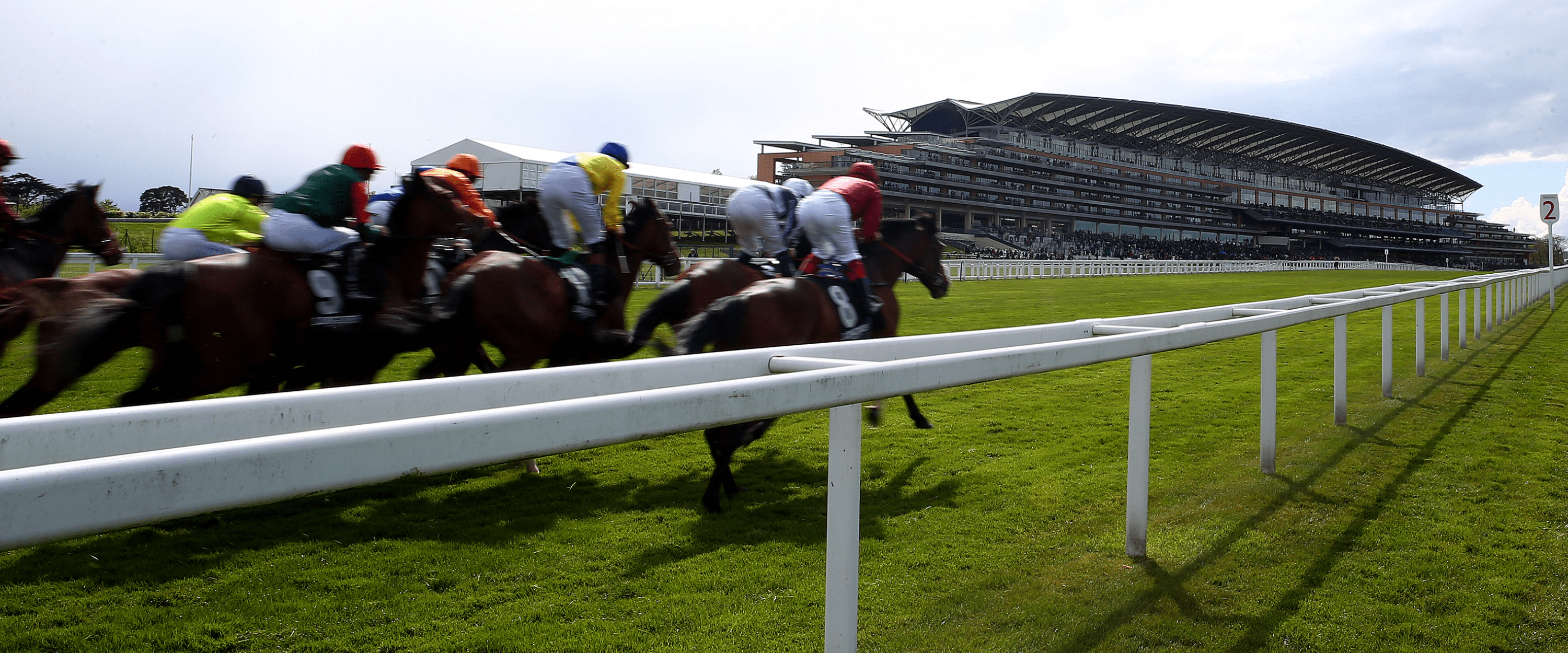 View of Ascot Racecourse with jockeys and horses racing during Royal Ascot