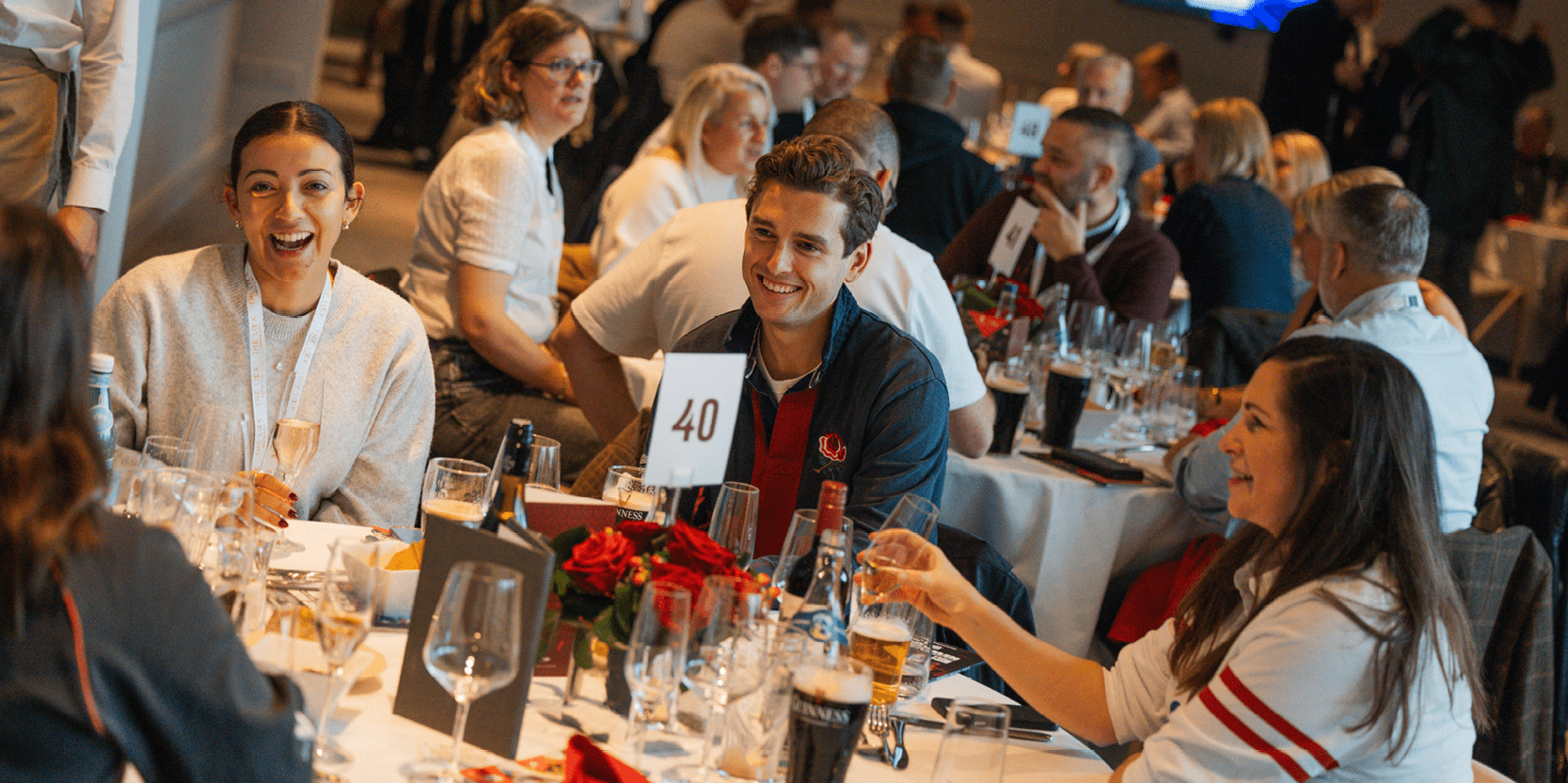 Guests in hospitality around a table at an England Rugby match at Allianz Stadium Twickenham laughing