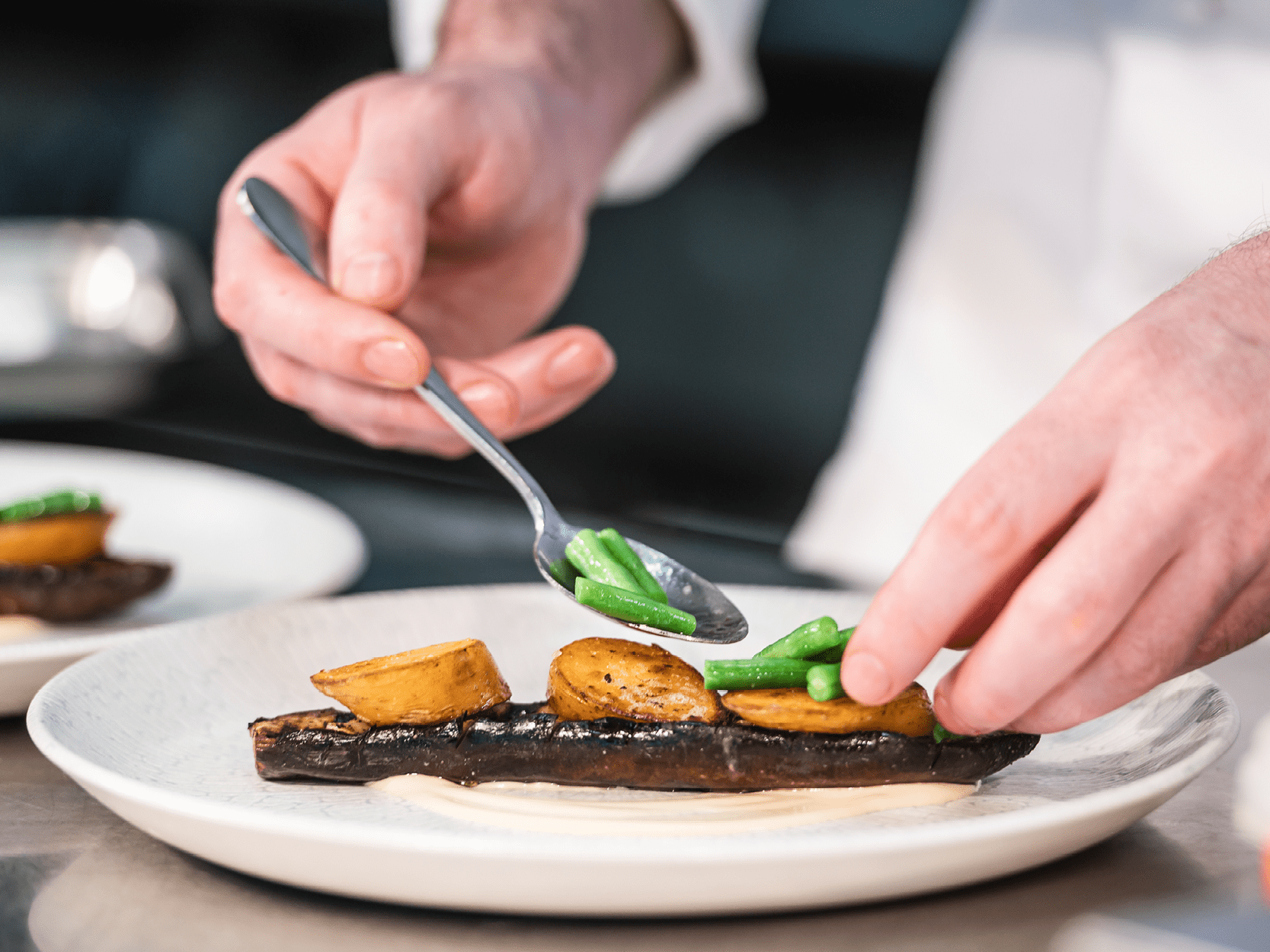 Chef Tom Shepherd plating up a dish at his menu tasting for Edgbaston Stadium's major match days in the Warwickshire Suite in 2025