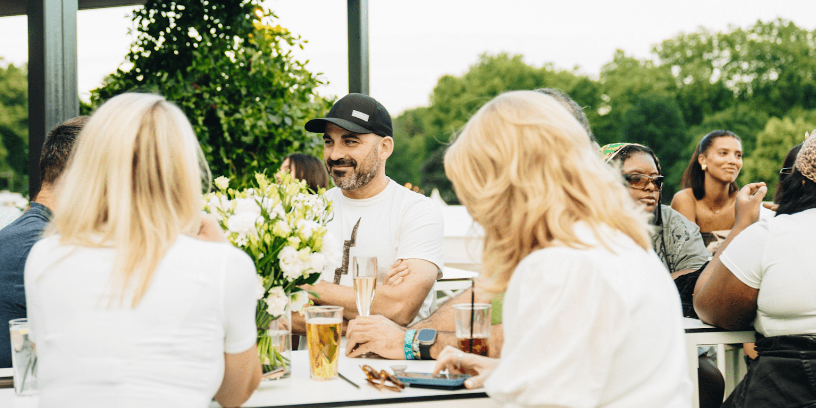 Guests in hospitality with Keith Prowse in the Great Oak Roof Garden at BST Hyde Park chatting and smiling