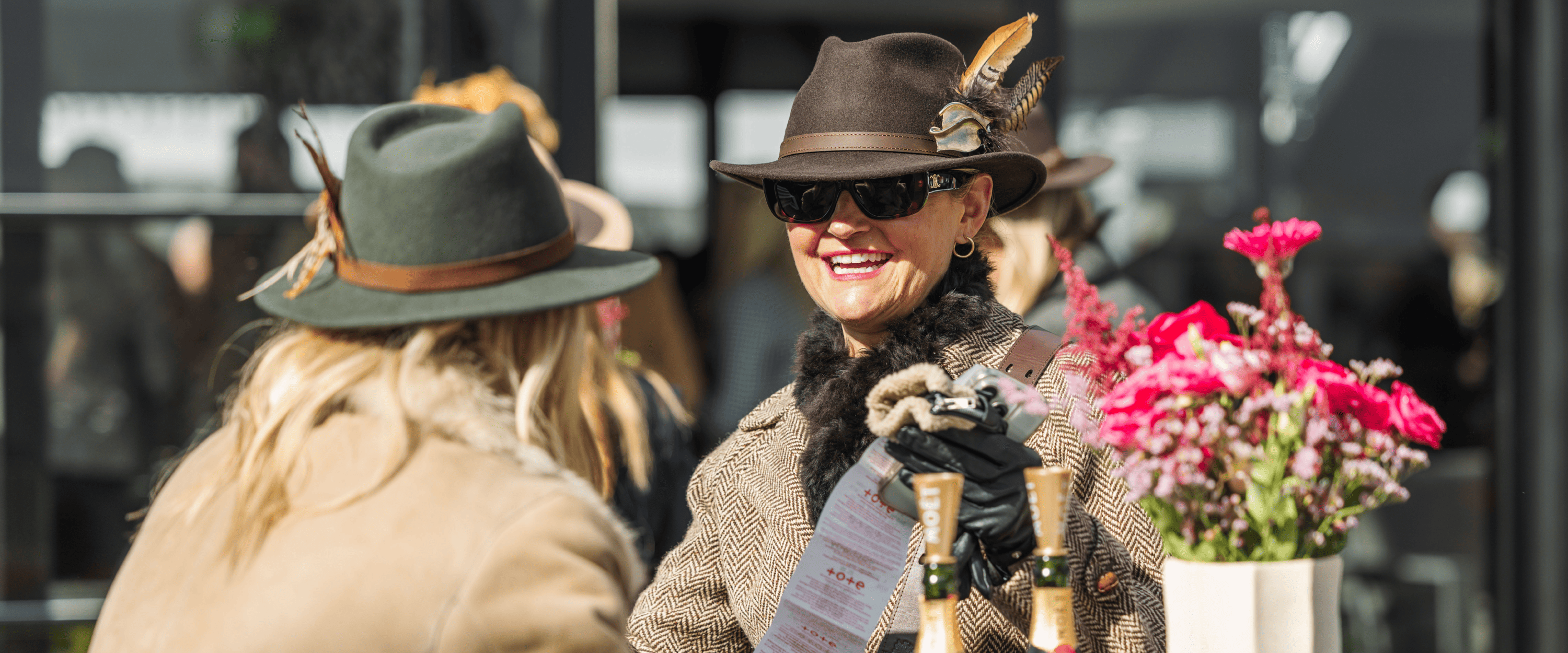 Guests smiling and chatting outside at Cheltenham Festival whilst enjoying hospitality experience at the horse racing