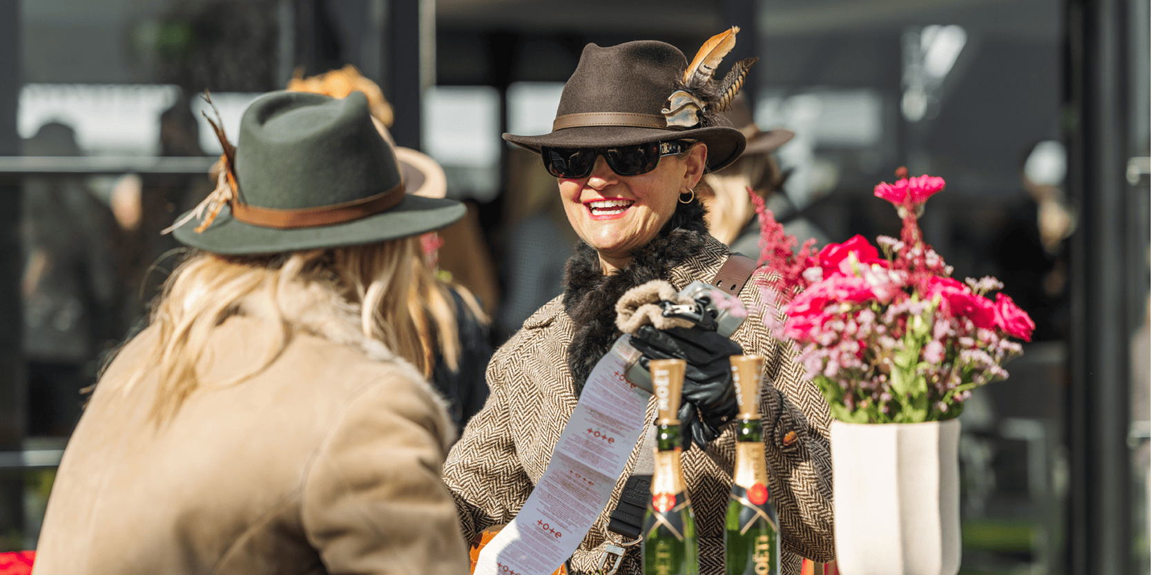 Guests in hospitality at the Cheltenham Festival smiling and drinking Champagne