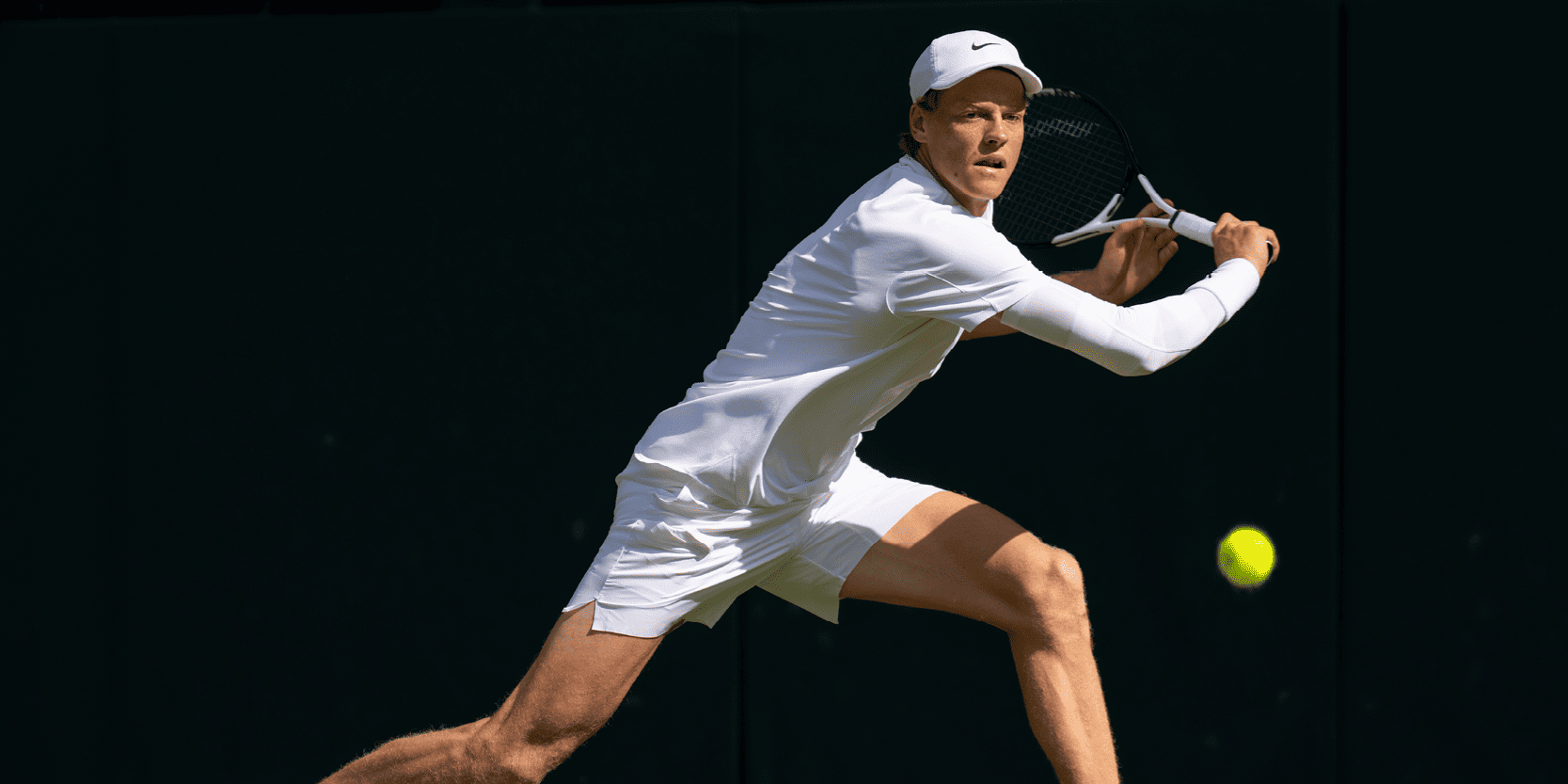 Men's tennis player Jannik Sinner hitting the ball during a match on Centre Court at Wimbledon in 2025
