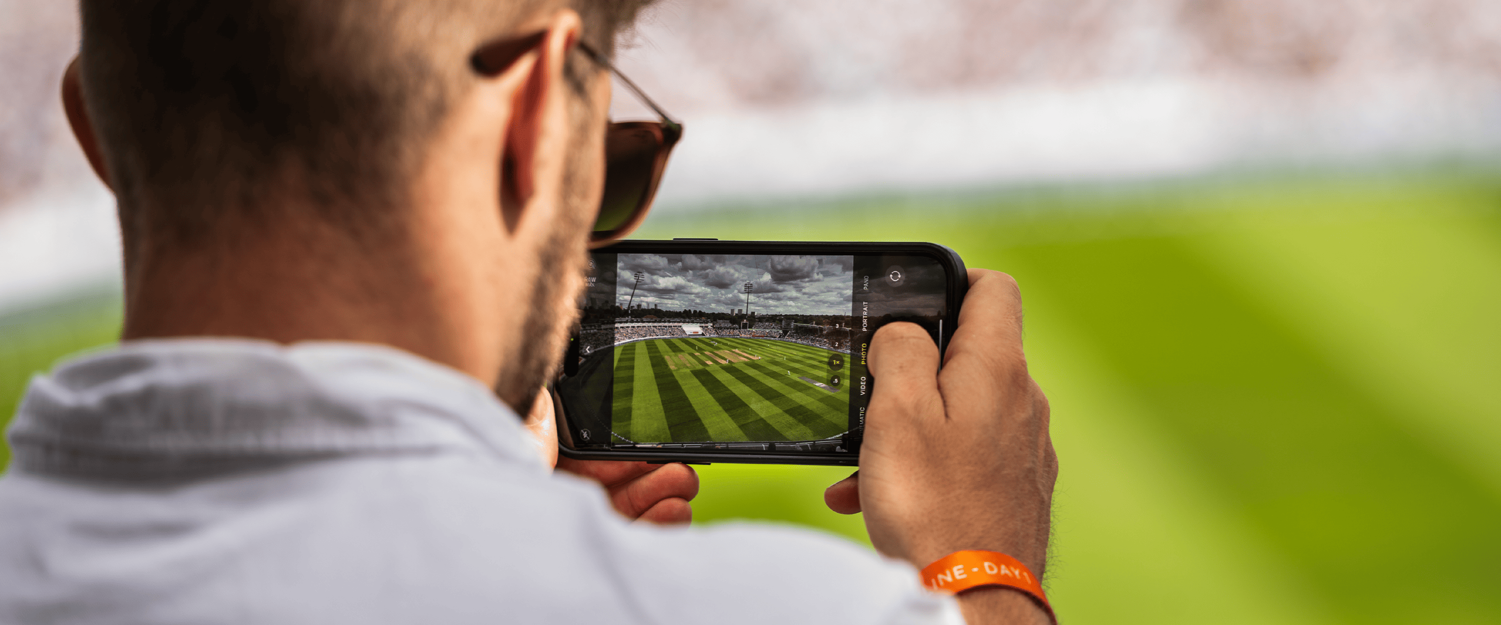 Cricket fan taking a photo of the pitch at Edgbaston Stadium