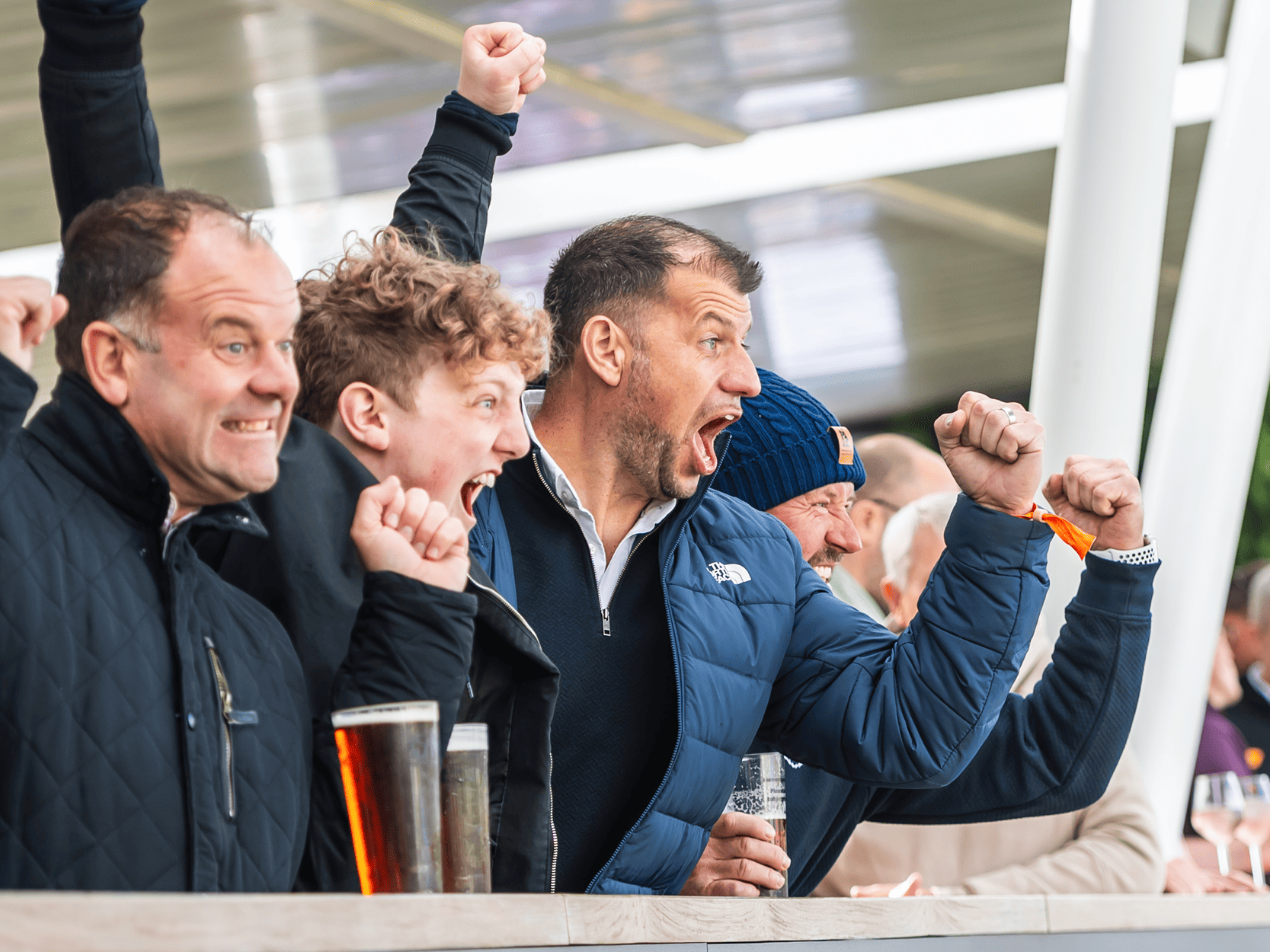 Cricket fans at Edgbaston Stadium celebrating and pumping their fists in the air