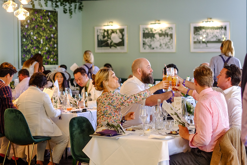 Guests doing cheers with their glasses in Rosewater Pavilion at Wimbledon