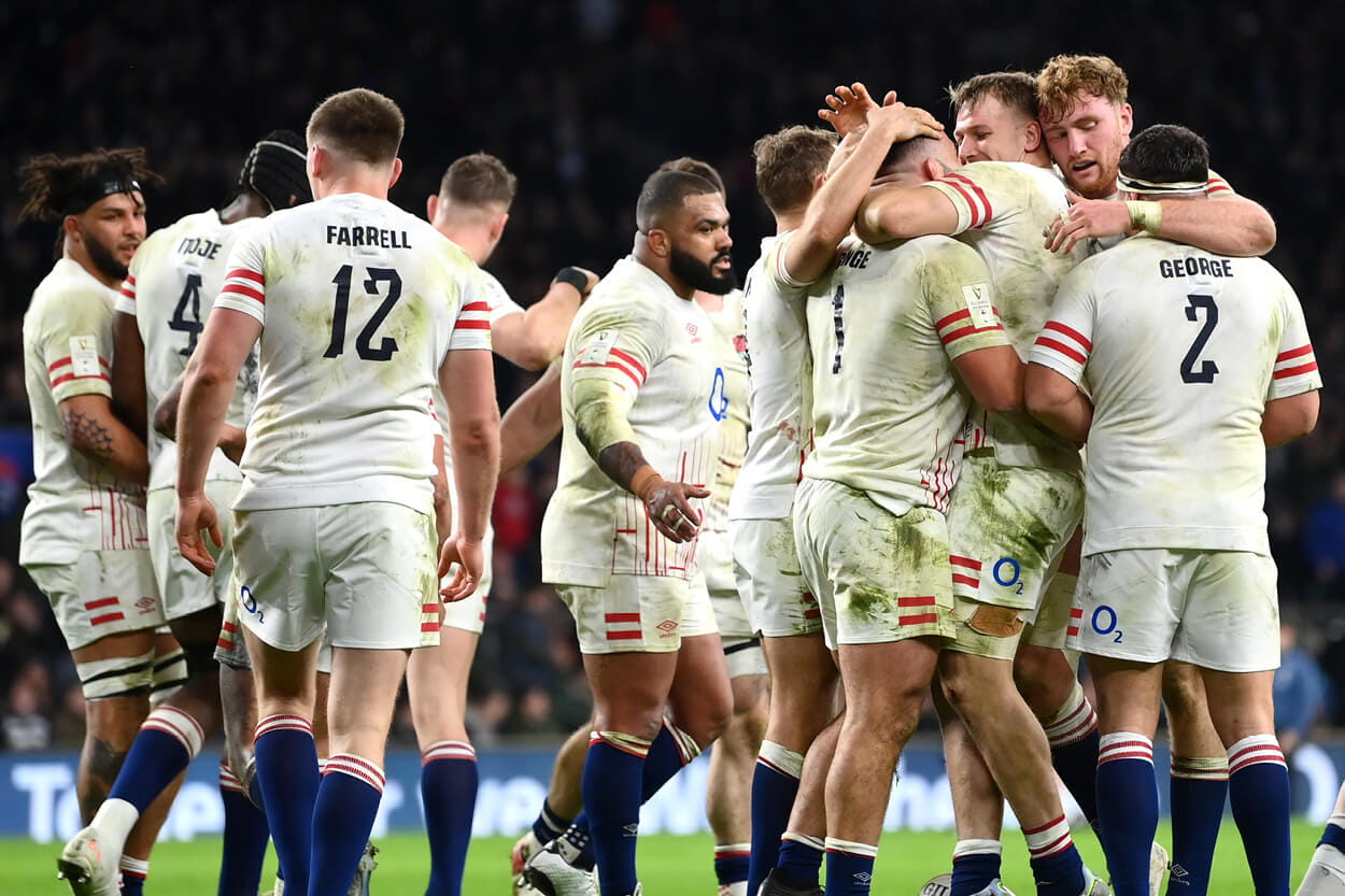 England rugby team hugging and celebrating scoring a point at Twickenham Stadium during a match