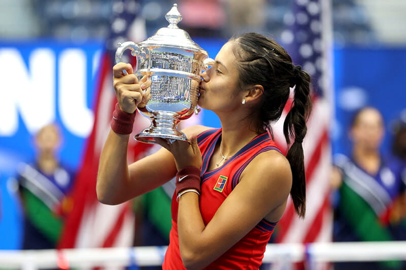 Emma Raducanu kissing her US Open trophy after her win