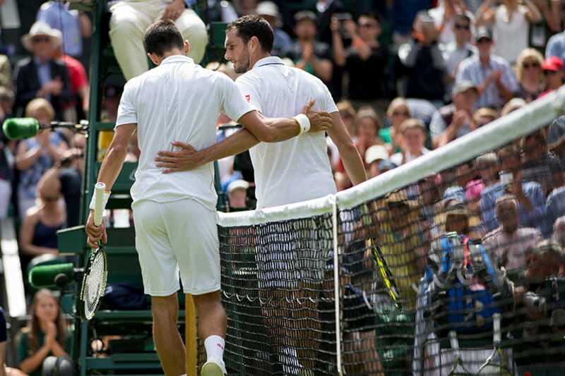 Tennis players talking after the match at the net at Wimbledon