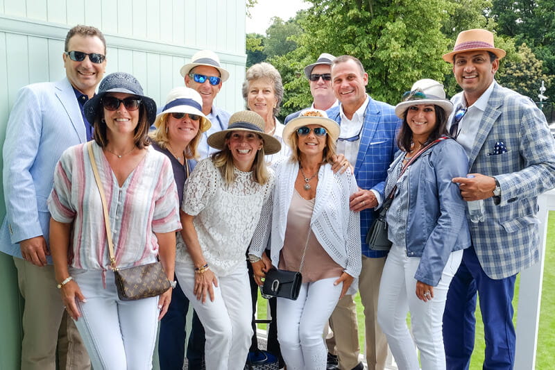 Guests smiling for a photo in Rosewater Pavilion hospitality with former British tennis player Greg Rusedski