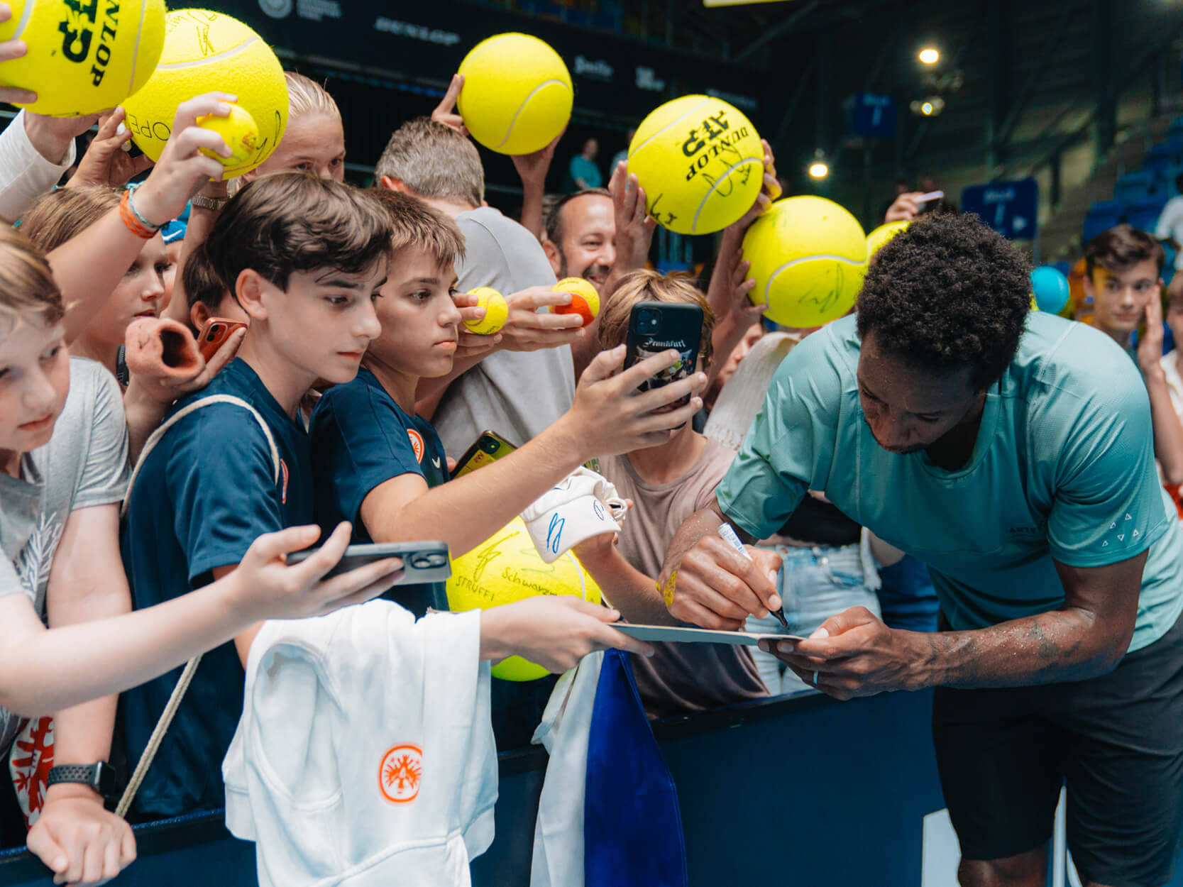 Tennis player Gael Monfils signing fans tennis balls at UTS tennis tournament