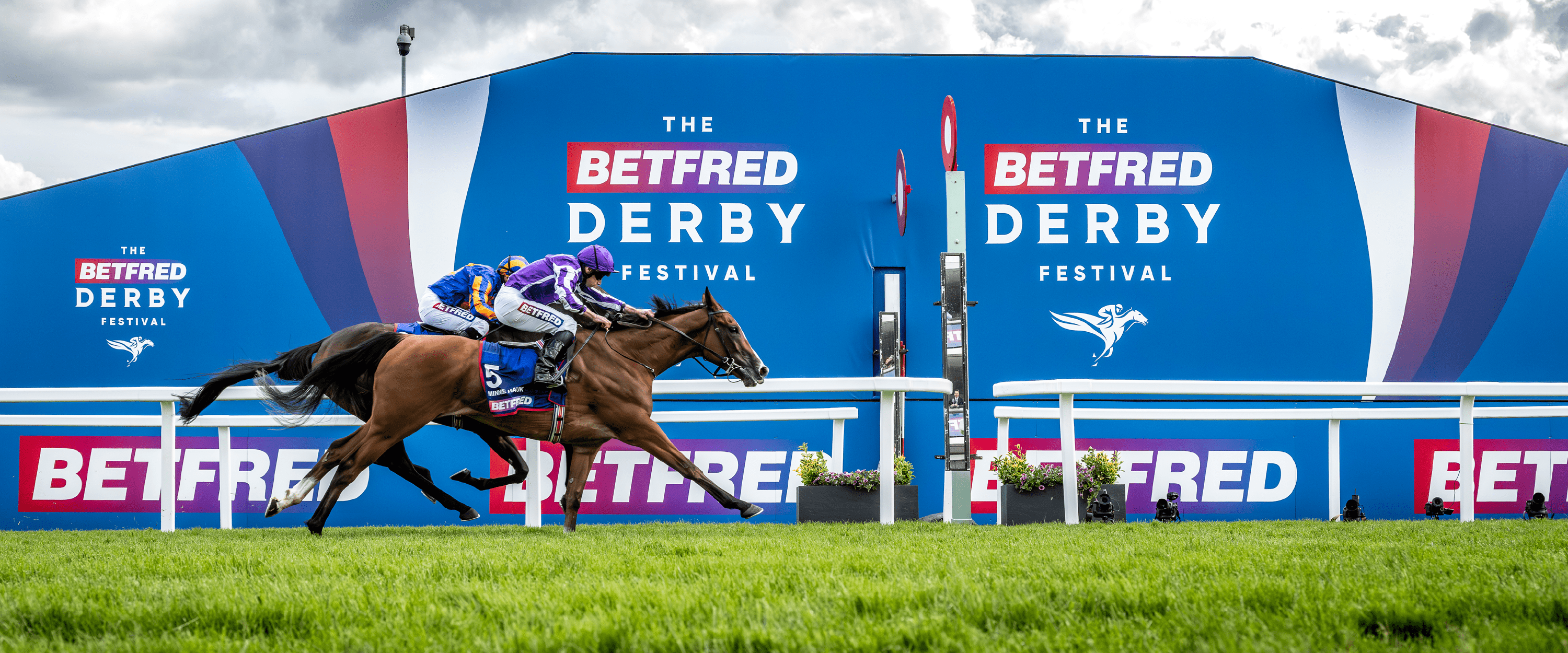 Jockey and horse crossing the finish line at the Betfred Derby Festival at Epsom Racecourse