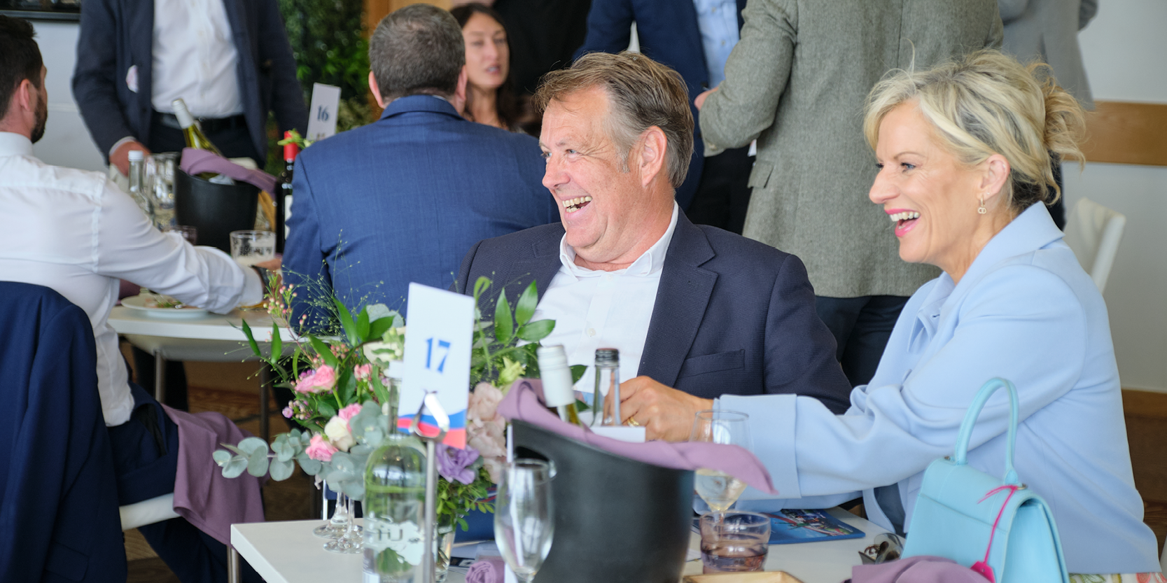 Guests in hospitality smiling and laughing at the Betfred Derby Festival at Epsom Racecourse