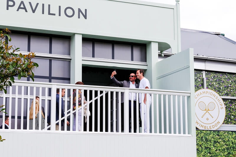 Greg Rusedski taking a photo with a guest outside Rosewater Pavilion hospitality facility at Wimbledon
