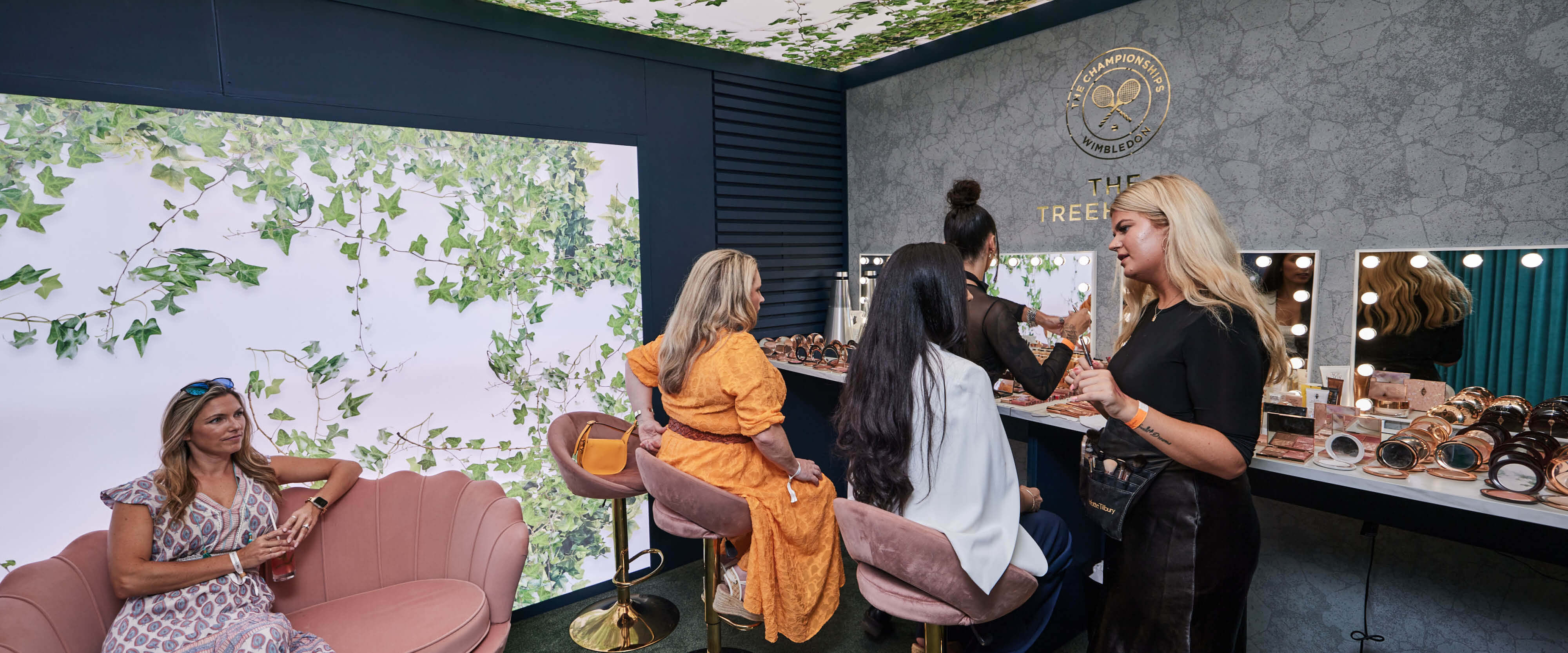 Guests getting their makeup touched up in the pamper room inside the Treehouse hospitality facility with makeup from Charlotte Tilbury cosmetics at The Championships Wimbledon